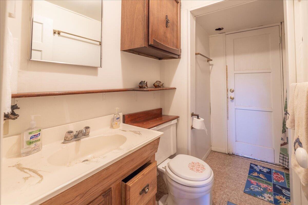 Full bathroom with wood vanity and mirrored cabinet